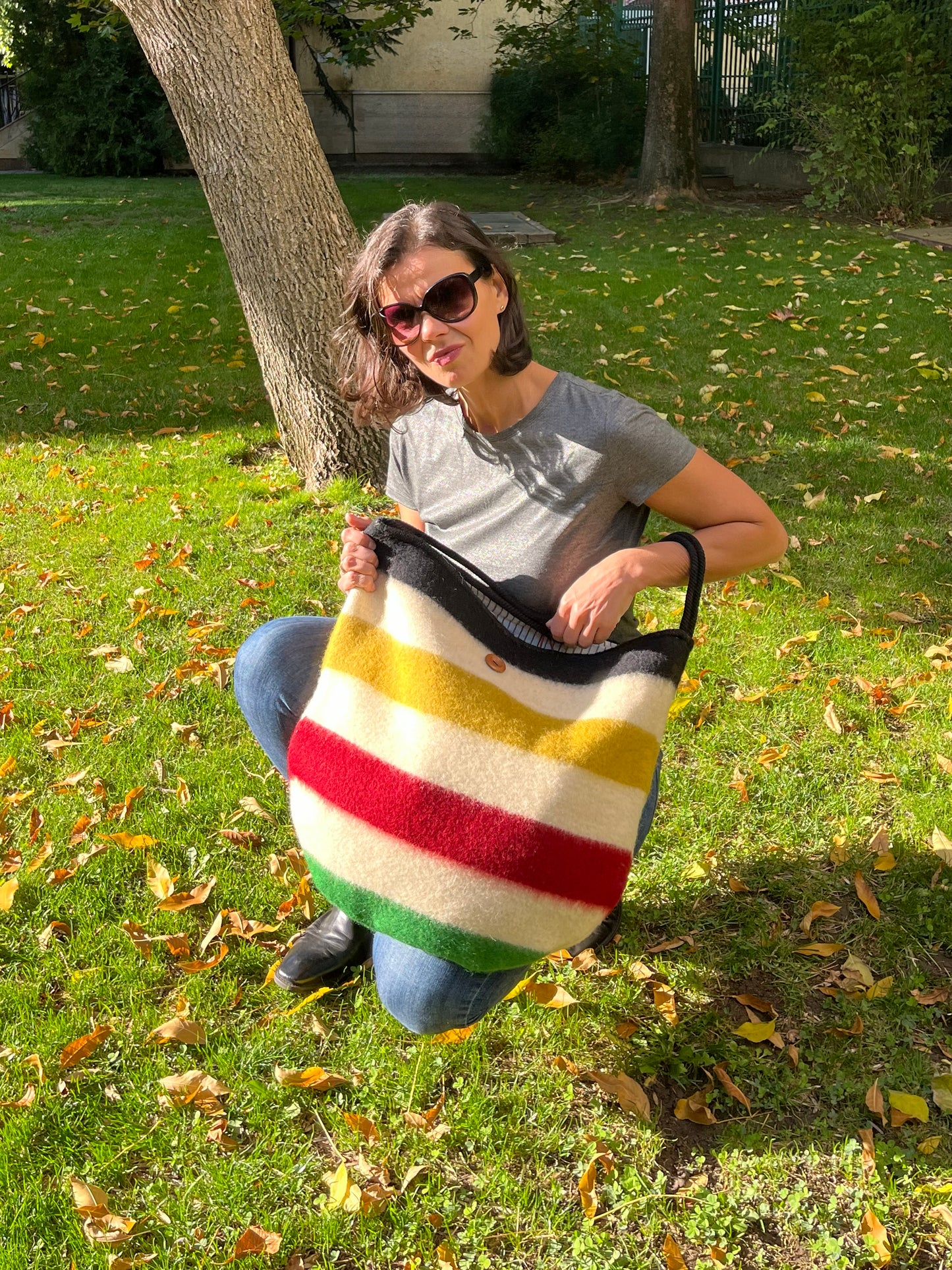 Woman holding a modern minimalistic multifunctional fashion bag made from luxurious virgin wool blanket cuts.