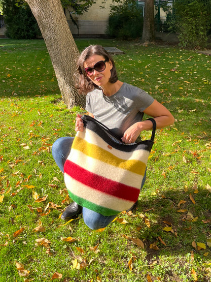 Woman holding a modern minimalistic multifunctional fashion bag made from luxurious virgin wool blanket cuts.