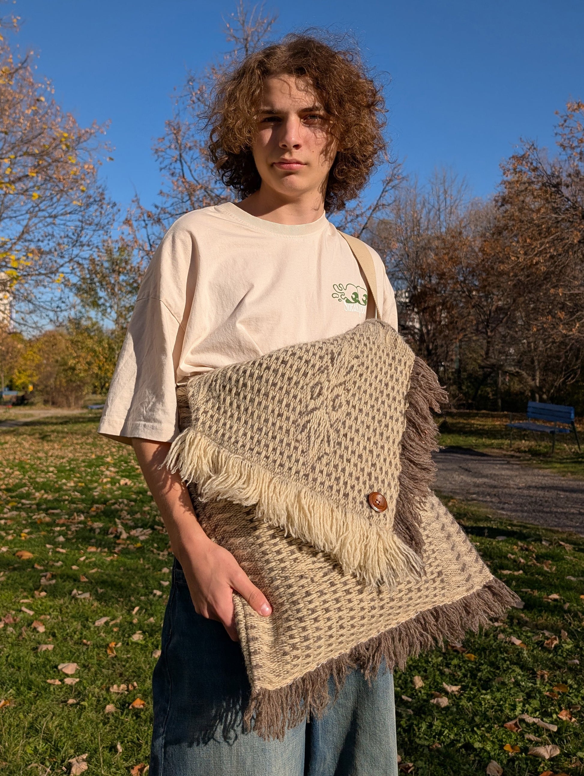 Man wearing a unisex, cross-shoulder large boho bag, made from handwoven structured wool blanket.