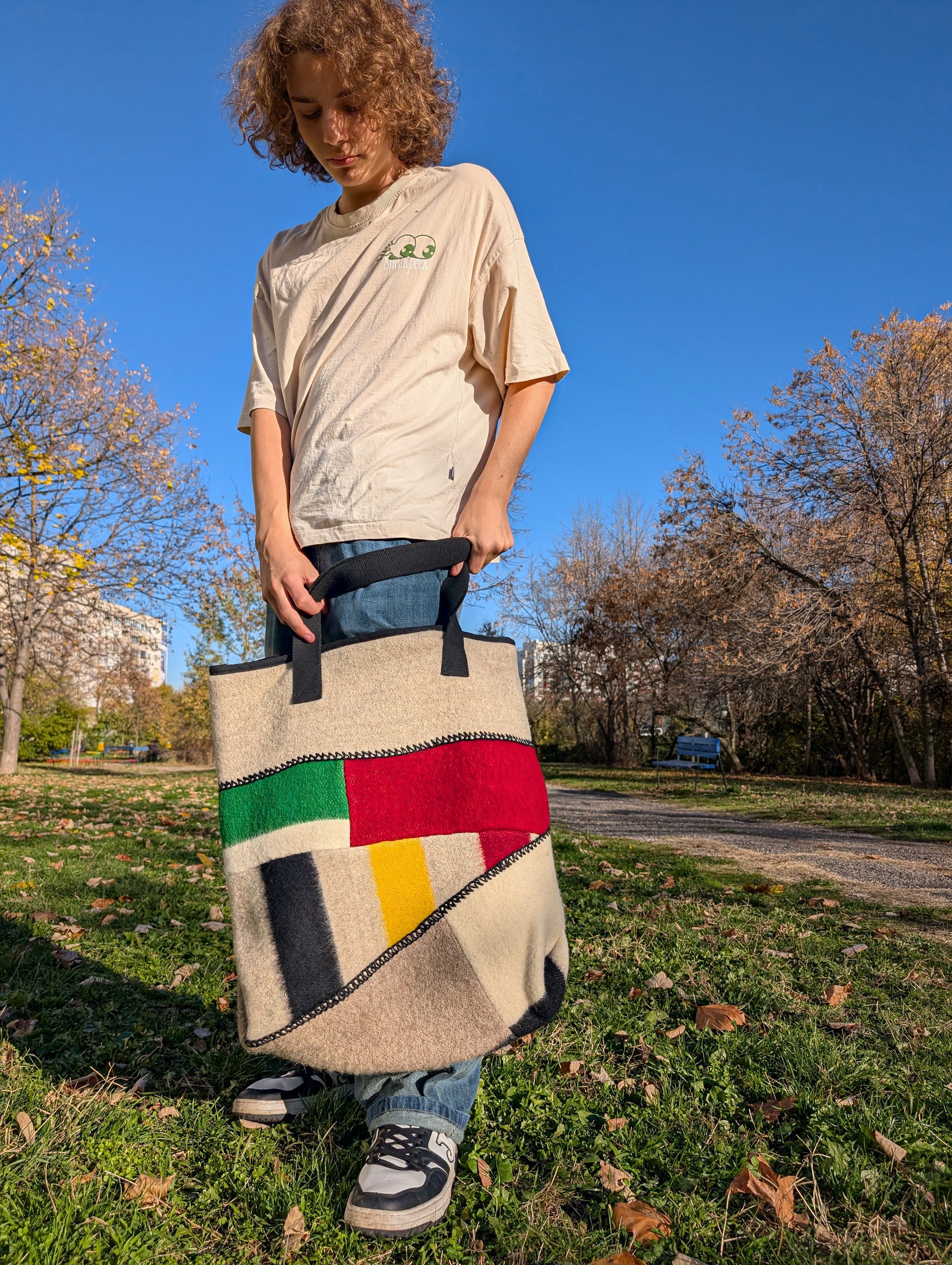 Person wearing a modern functional designer bag made of traditional heritage wool blanket cuts.
