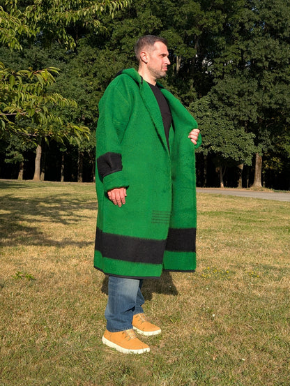 Man wearing a green blanket coat with black stripes made from repurposed authentic wool blanket.