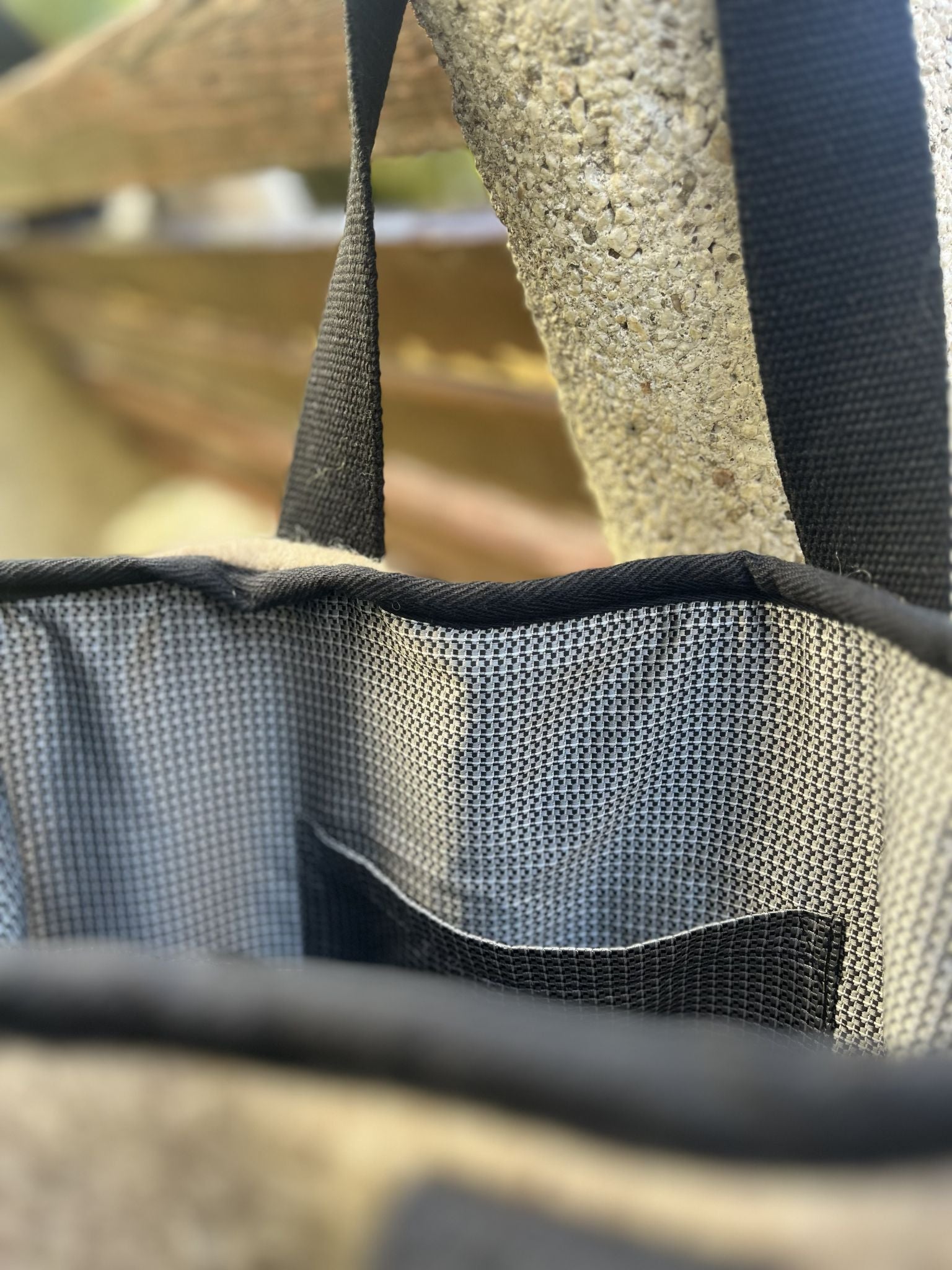 Close-up of a beautiful plaid satinated cotton lining of a wool tote bag with a strap and inside pocket.