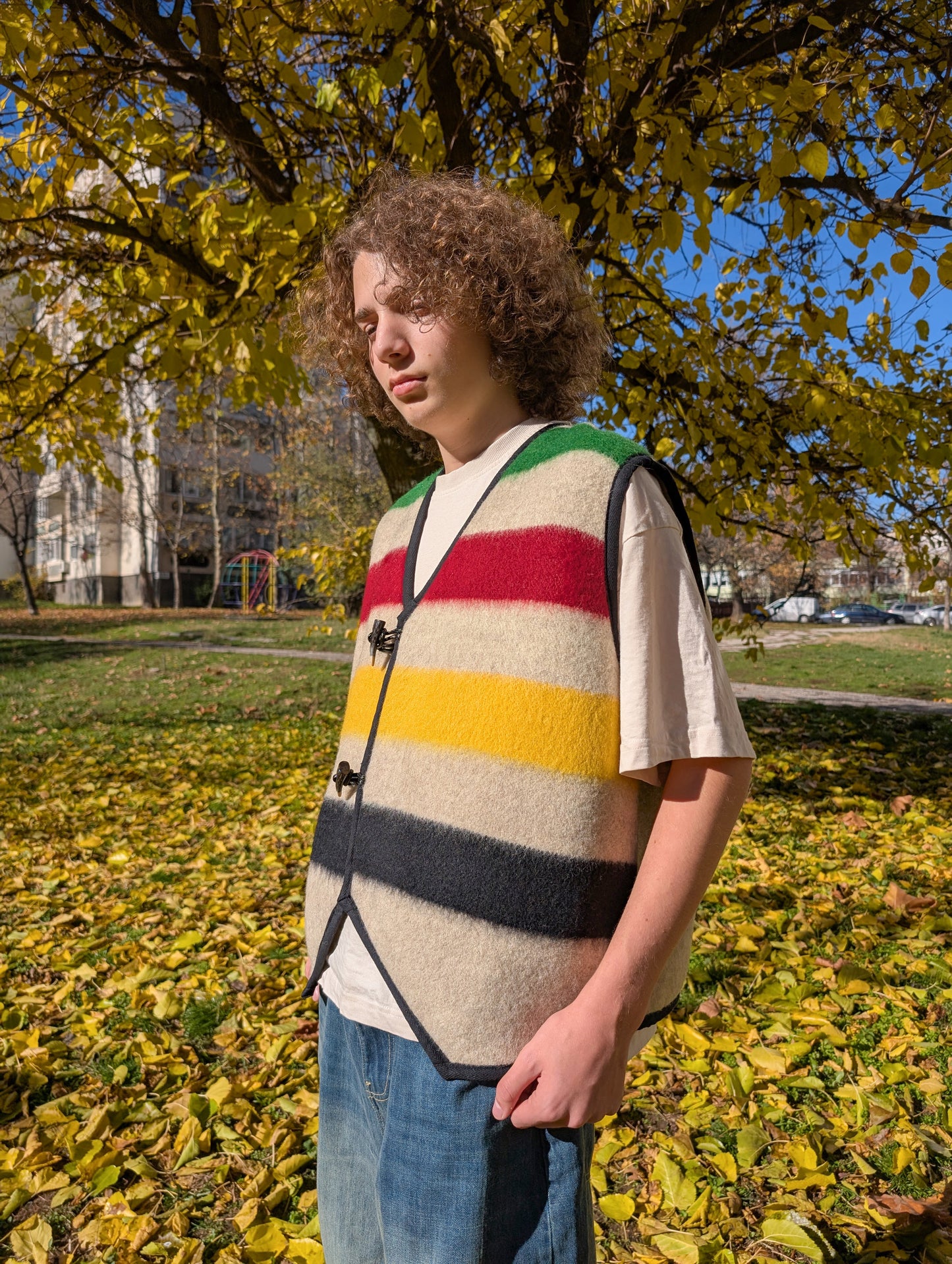 Man wearing a stylish statement stripe vest, made of wool blanket, with toggle closure. Unisex and great on all ages, suitable for everyday wear, events, and walks in the nature.