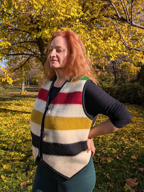 Woman wearing a stylish unisex cropped gilet, tailor made from repurposed blanket and worn as a slow fashion statement piece.