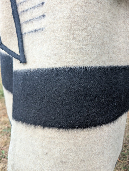 A detail of a blanket coat featuring thick authentic pure virgin wool texture of upcycled wool blanket jacket.