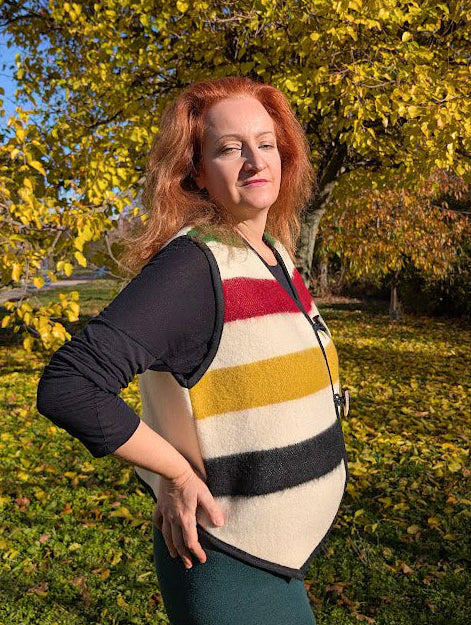 Woman wearing a one-of-a-kind statement iconic vest, made from a wool blanket and great for reenactment, everyday walks, casual wear and styling. A unisex made-to-order vest, perfect for all ages and all ocassions.