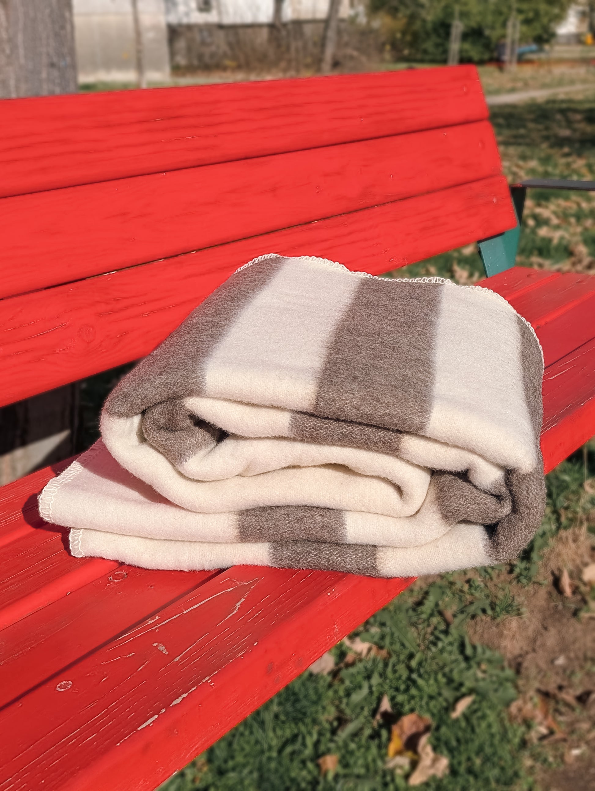 Naturally colored striped blanket made from undyed, sustainable pure sheep wool, handcrafted in a small artisan studio.