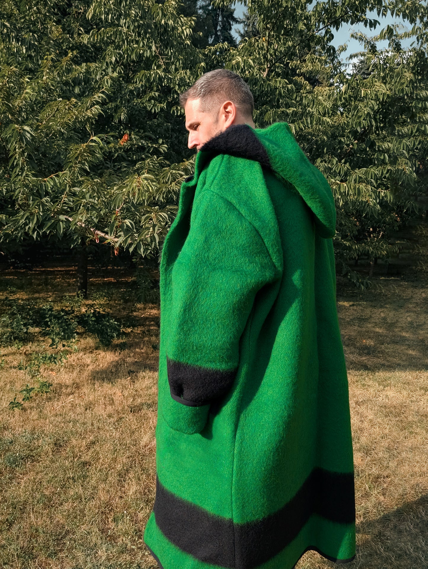 Person wearing a long hooded wrap coat or robe coat ina loose and free every day style. A pure wool upcycled piece.