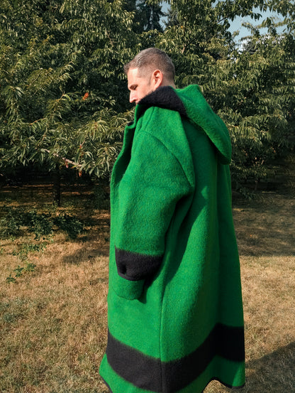Person wearing a long hooded wrap coat or robe coat ina loose and free every day style. A pure wool upcycled piece.