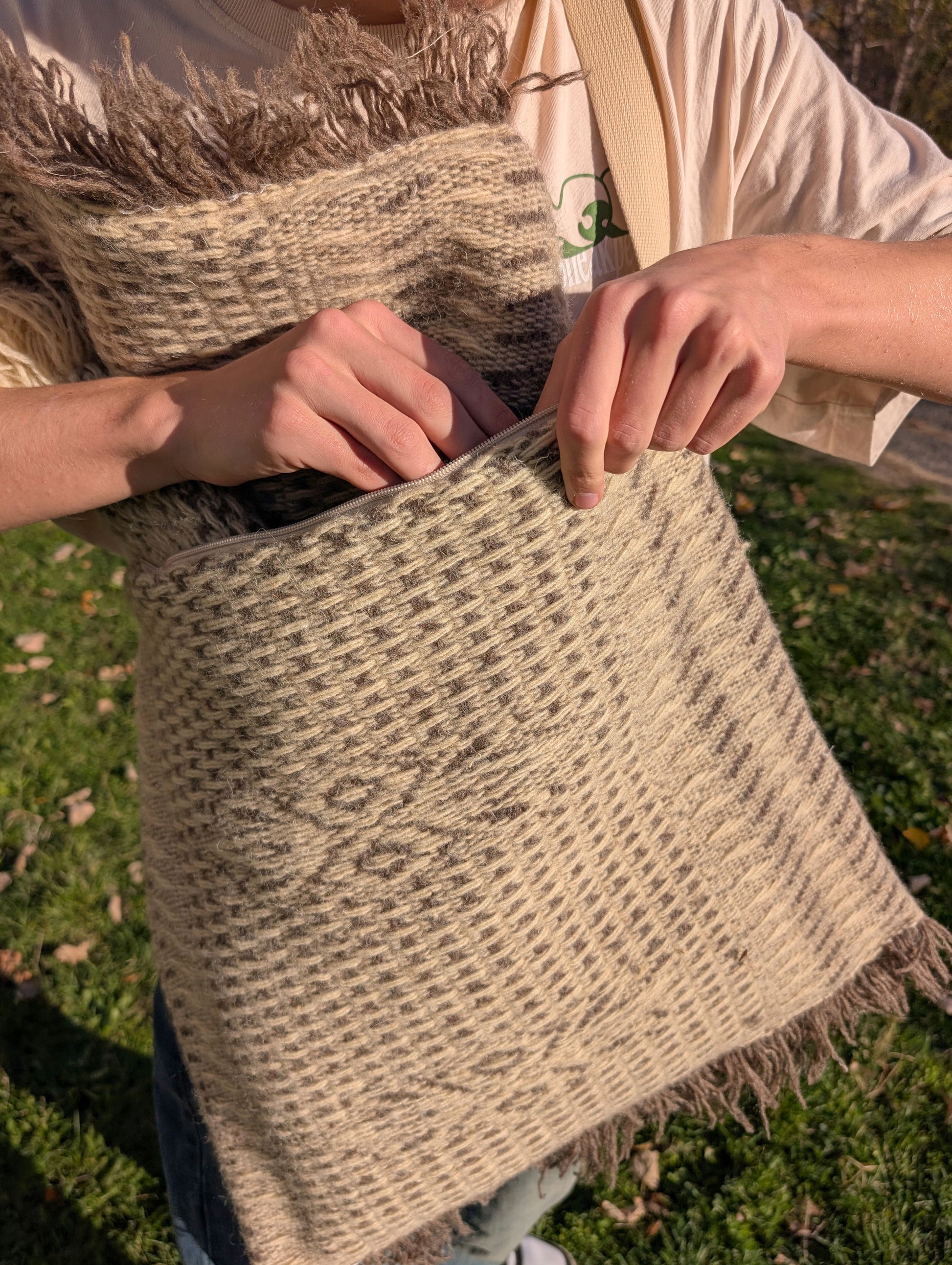 Close-up of a handmade artisan messenger bag made of organic wool blanket, with textured knotted weave structure.