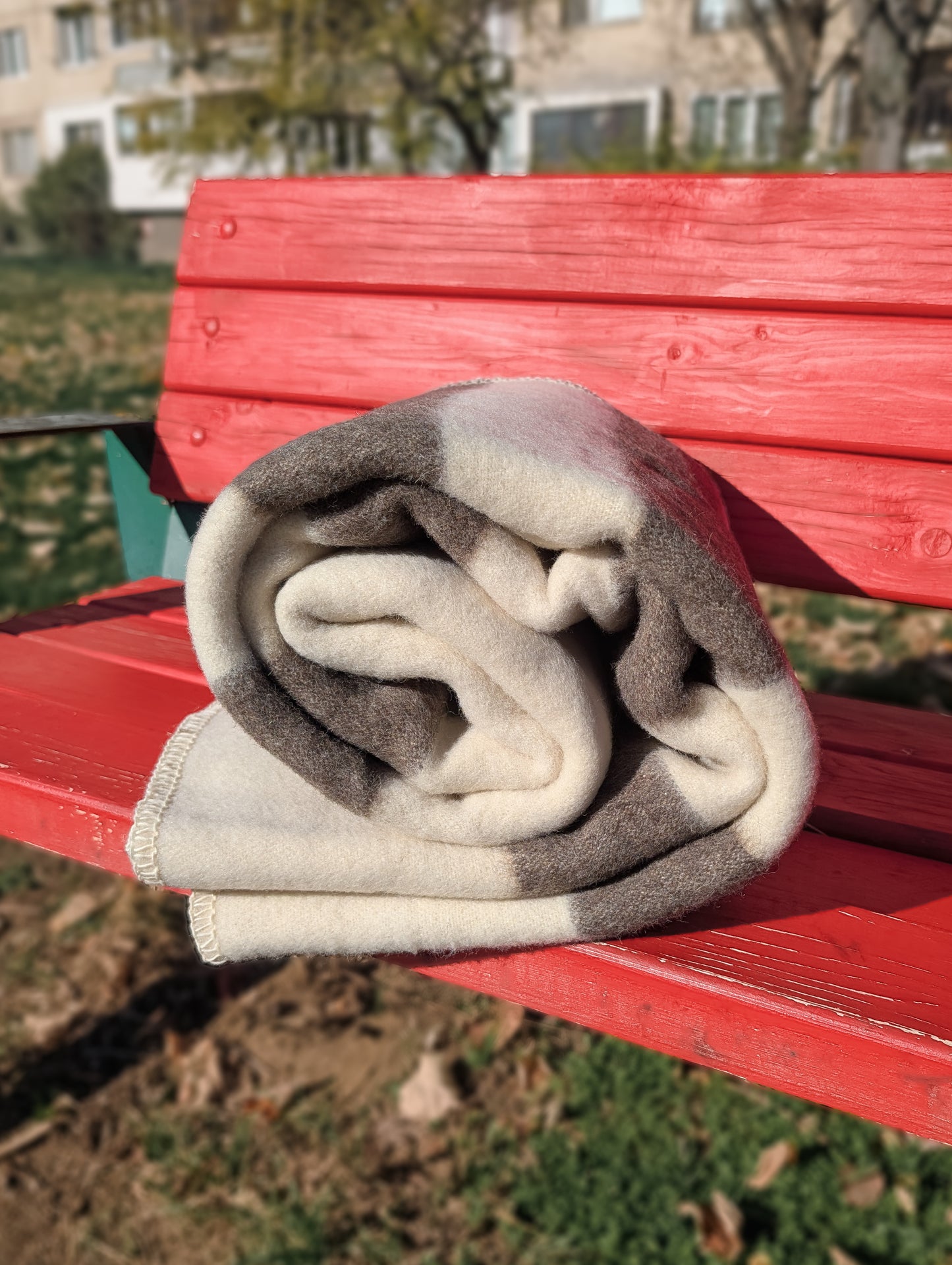 Folded minimalist stripe throw, woven from undyed natural sustainable wool, ideal for rustic and modern interior, and outdoor camping