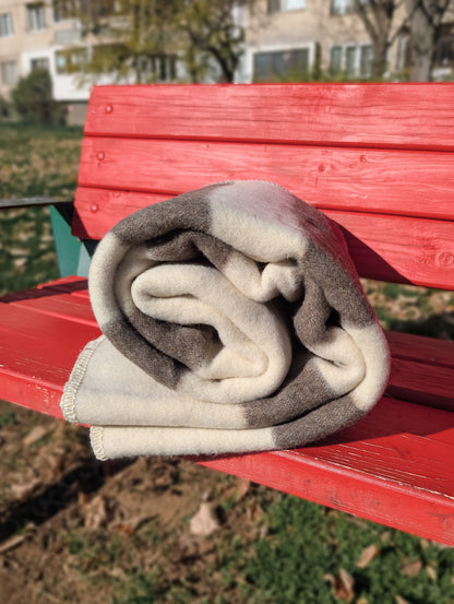 Folded minimalist stripe throw, woven from undyed natural sustainable wool, ideal for rustic and modern interior, and outdoor camping