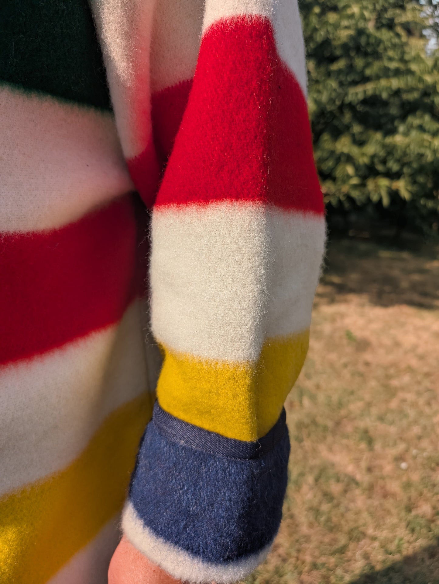 Close-up of a colorful striped sleeve with red, white, yellow, and blue stripes, outdoors.