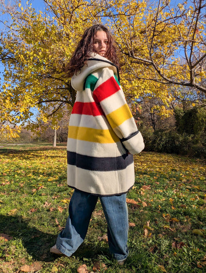 Woman standing backwards with a midi blanket capote coat or swing coat, made from handmade wool blanket.