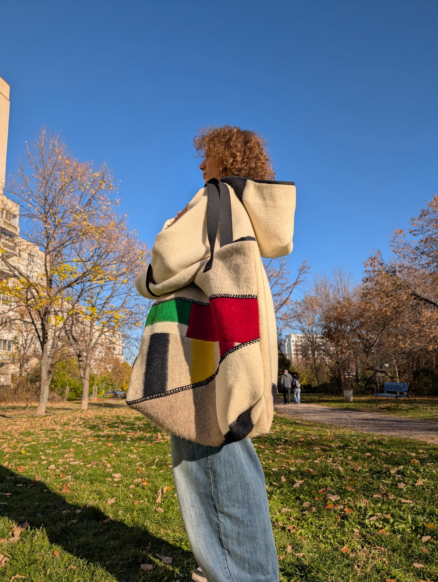 Person stading with his modern patchwork shoulder bag made from traditional ethnic handwoven blanket cuts.