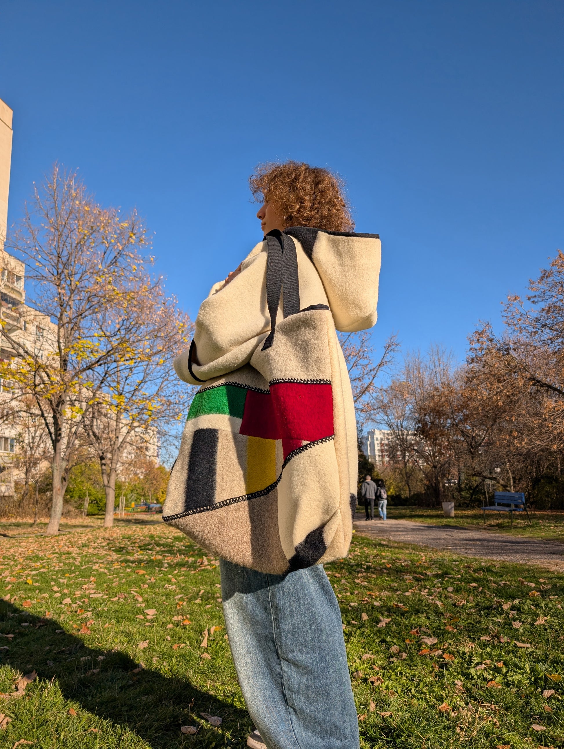 Person stading with his modern patchwork shoulder bag made from traditional ethnic handwoven blanket cuts.