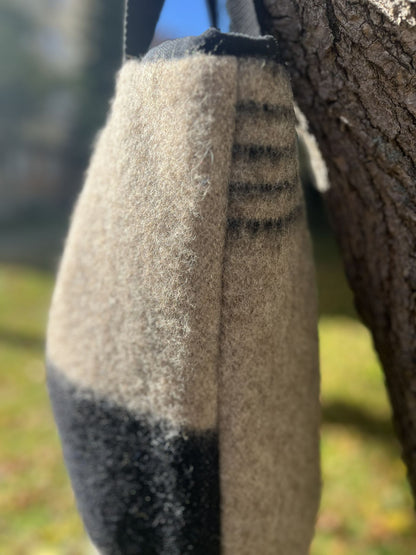 Handmade soft gray woolen tote bag exposed on a natuaral setting.