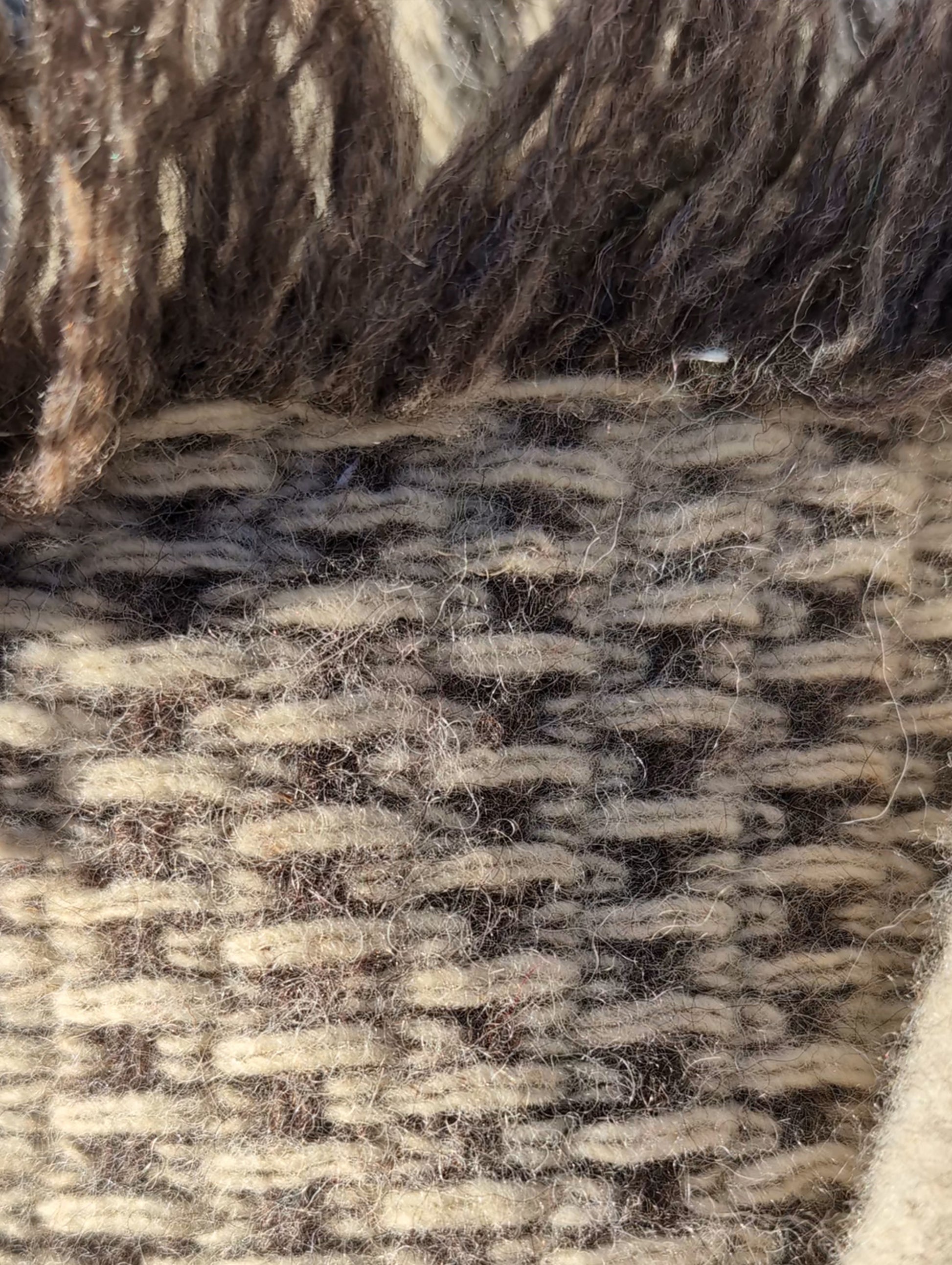 Close-up of handwoven woolen blanket repurposed for chic boho minimalist handmade bags.