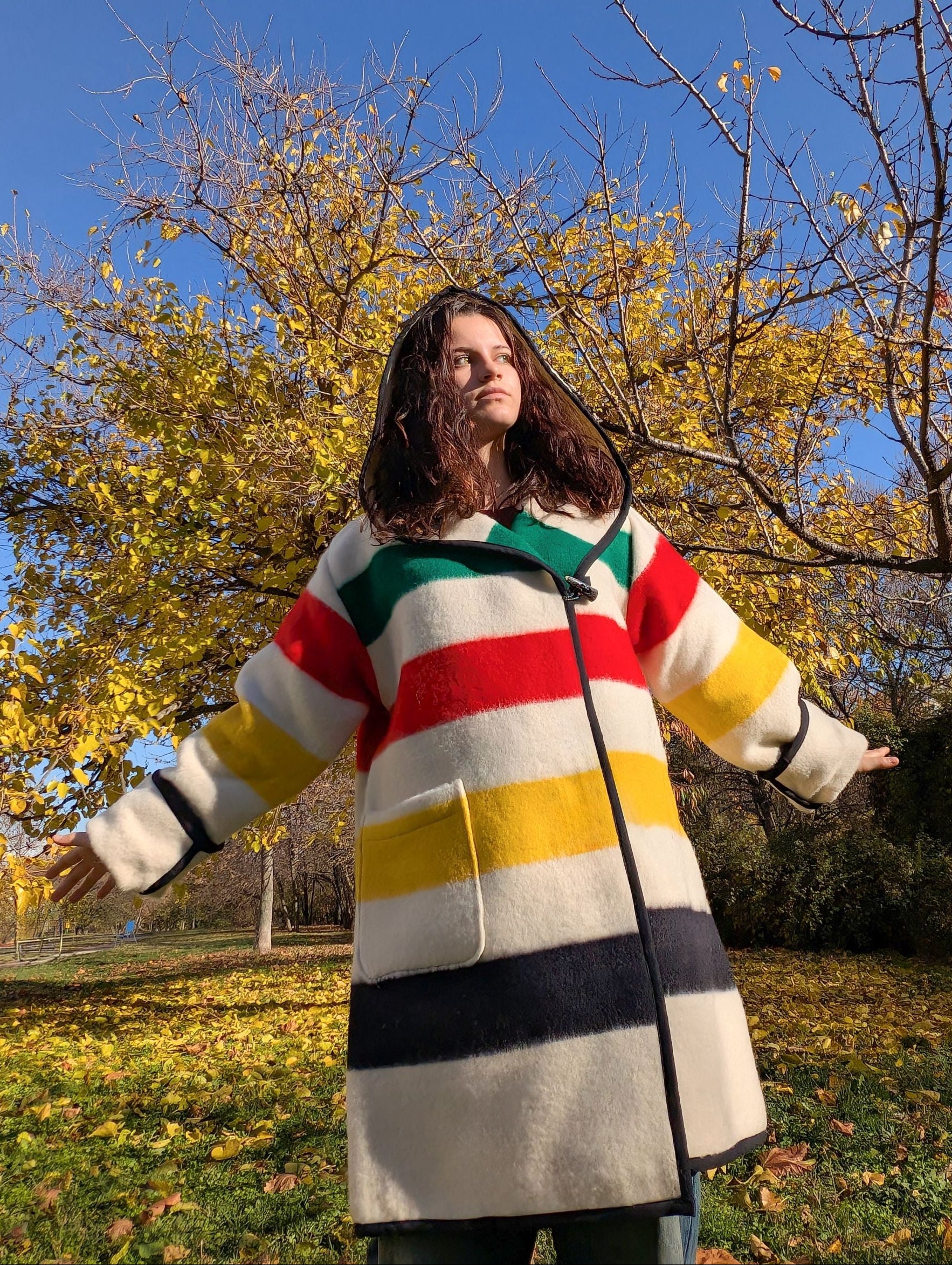 Woman wearing a colorful striped blanket coat made from traditional wool blankets