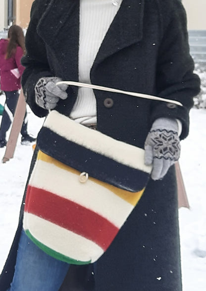 Woman holding a colorful striped bag in a snowy setting