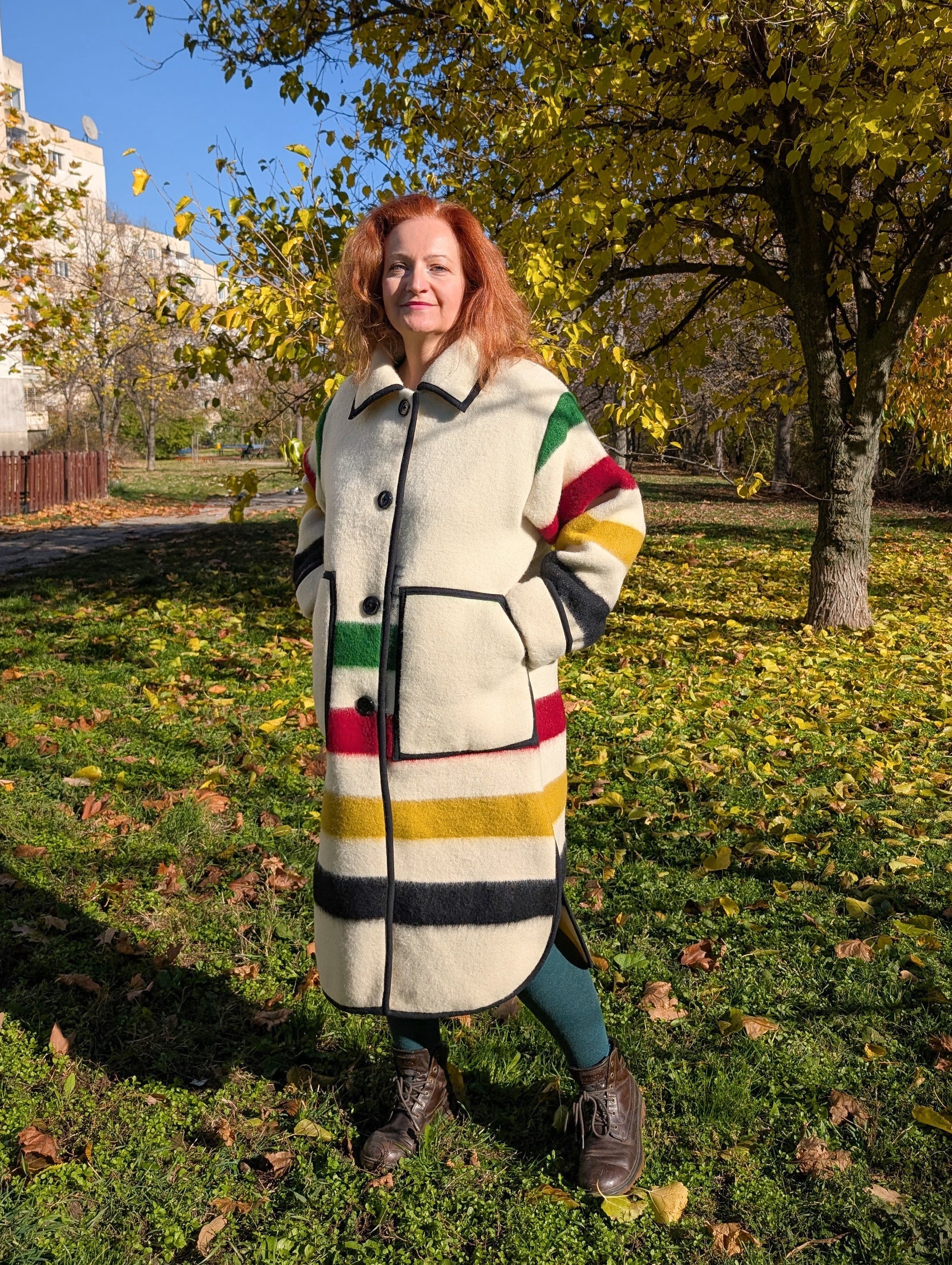 A woman wearing a blanket duster coat with classic collar and single breasted button closure.