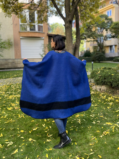 Person wearing a blue cape, upcycled from a new handmade virgin wool traditional blanket.