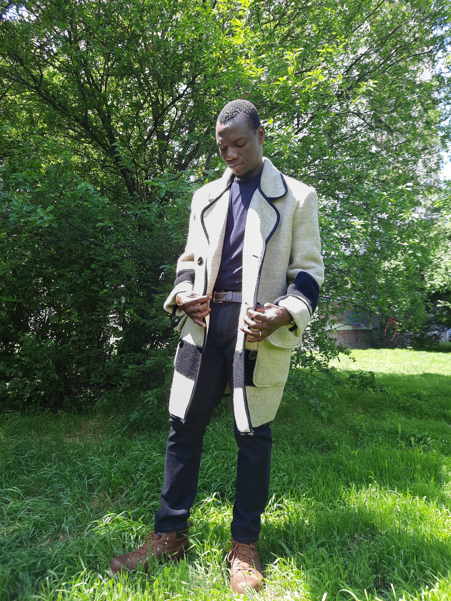 Man in a statement recycled blanket coat with black stripes, made of virgin wool blanket.