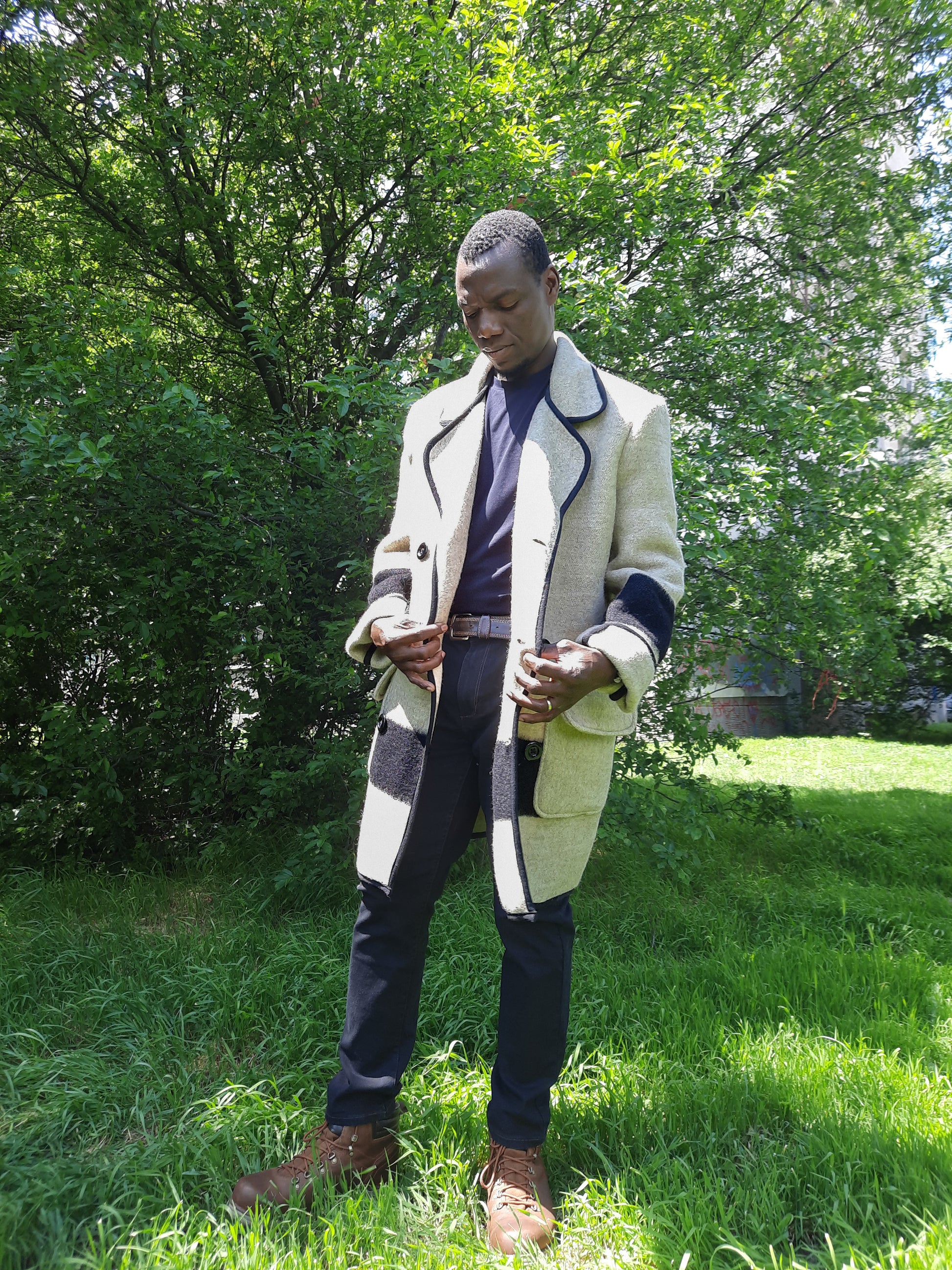 Man in a statement recycled blanket coat with black stripes, made of virgin wool blanket.