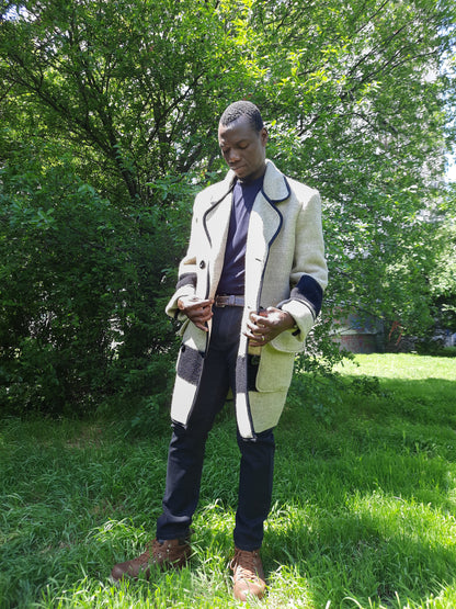 Man in a statement recycled blanket coat with black stripes, made of virgin wool blanket.