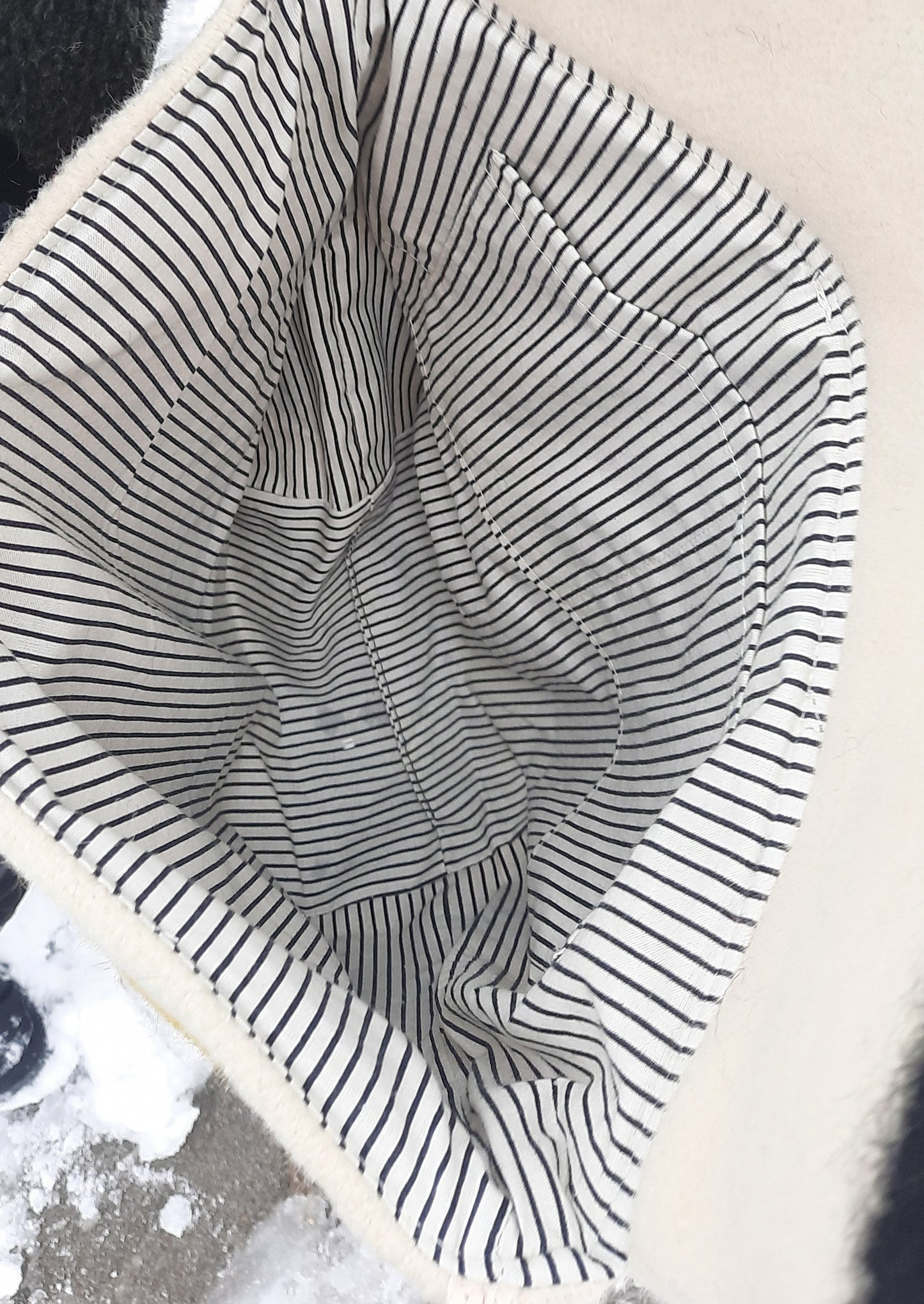 Close-up of a tote bag interior lining,  sewn from striped cotton fabric with black and white lines.