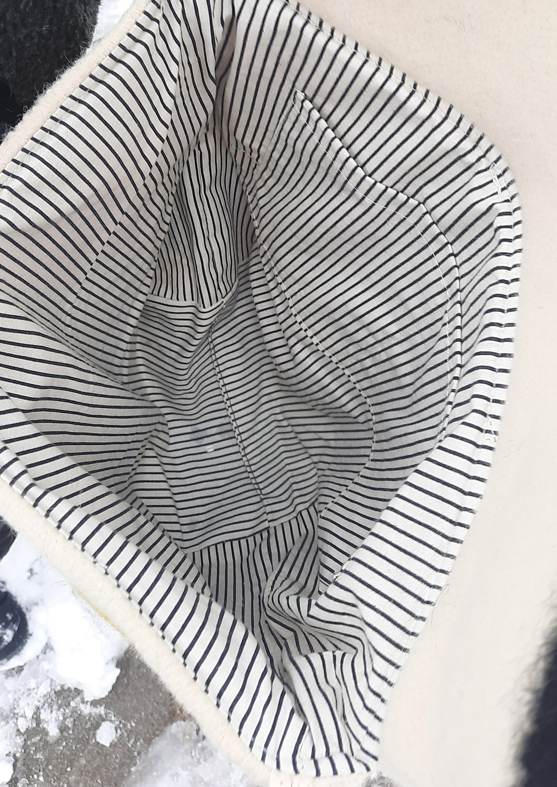 Close-up of a tote bag interior lining,  sewn from striped cotton fabric with black and white lines.