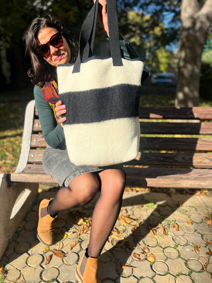 Woman holding a soft beautiful cream tote bag, ideal for sporty-elegant everyday urban wear and walks.