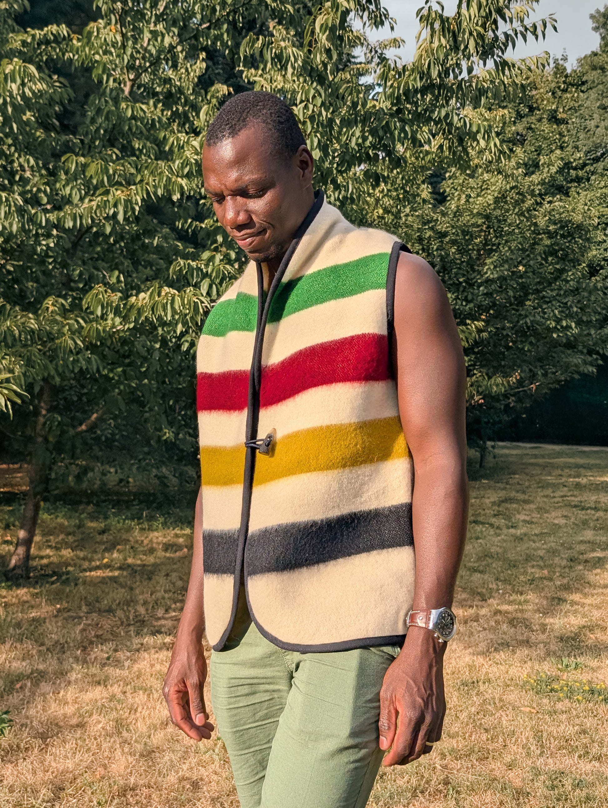 Man wearing sleeveless woolen jacket or woolen vest out in a park setting