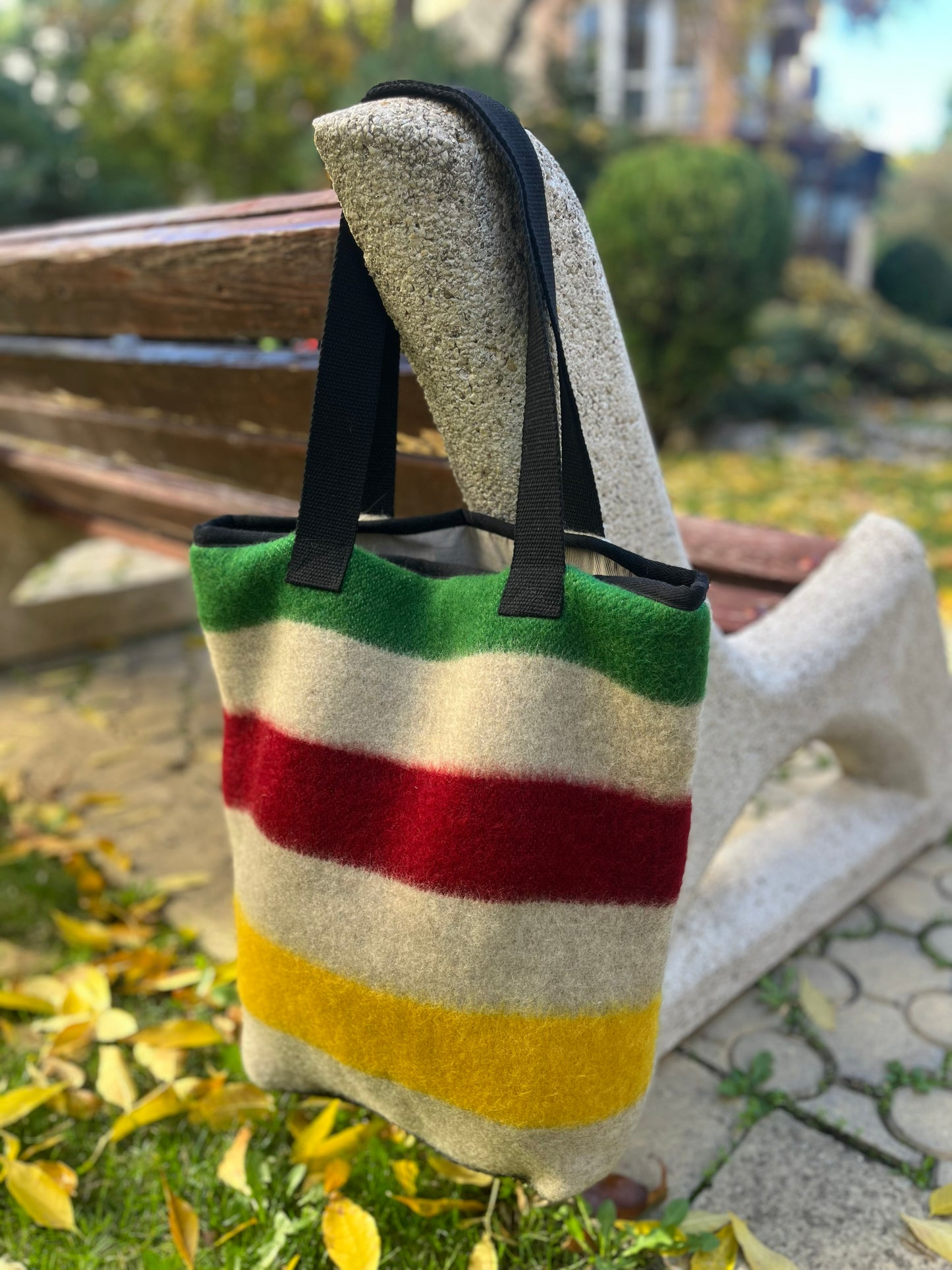 A functional shopper bag in first nations' style or tote bag, tailored from recycled traditional classic multistriped blankets.