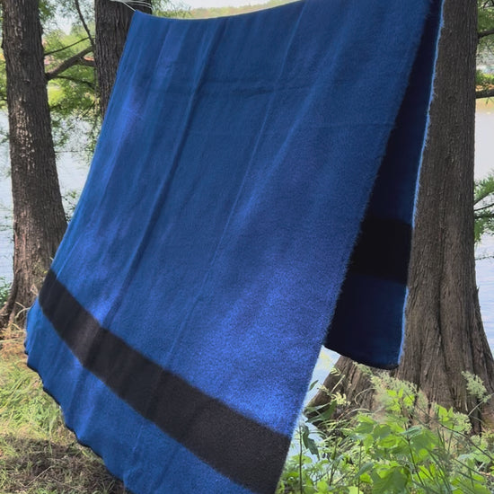 video of a native pioneer blanket draped on a rope in a wild forest setting.