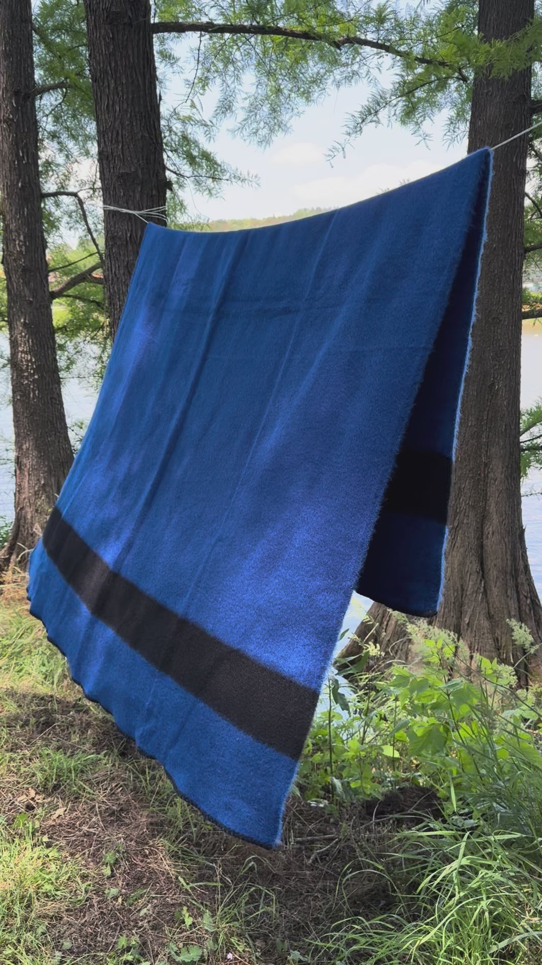 video of a native pioneer blanket draped on a rope in a wild forest setting.