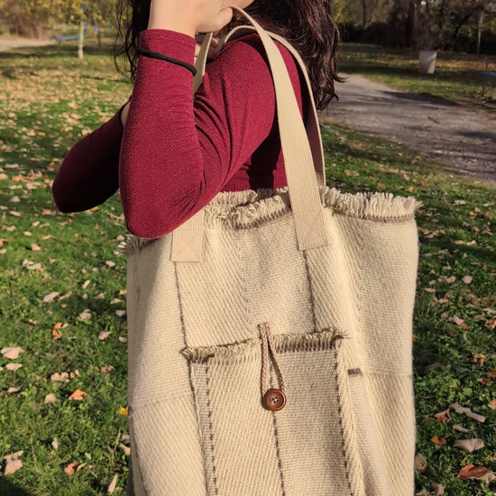 A video of a young girl wearing a modern minimalistic shopper bag or wool tote bag made from upcycled traditional blanket.