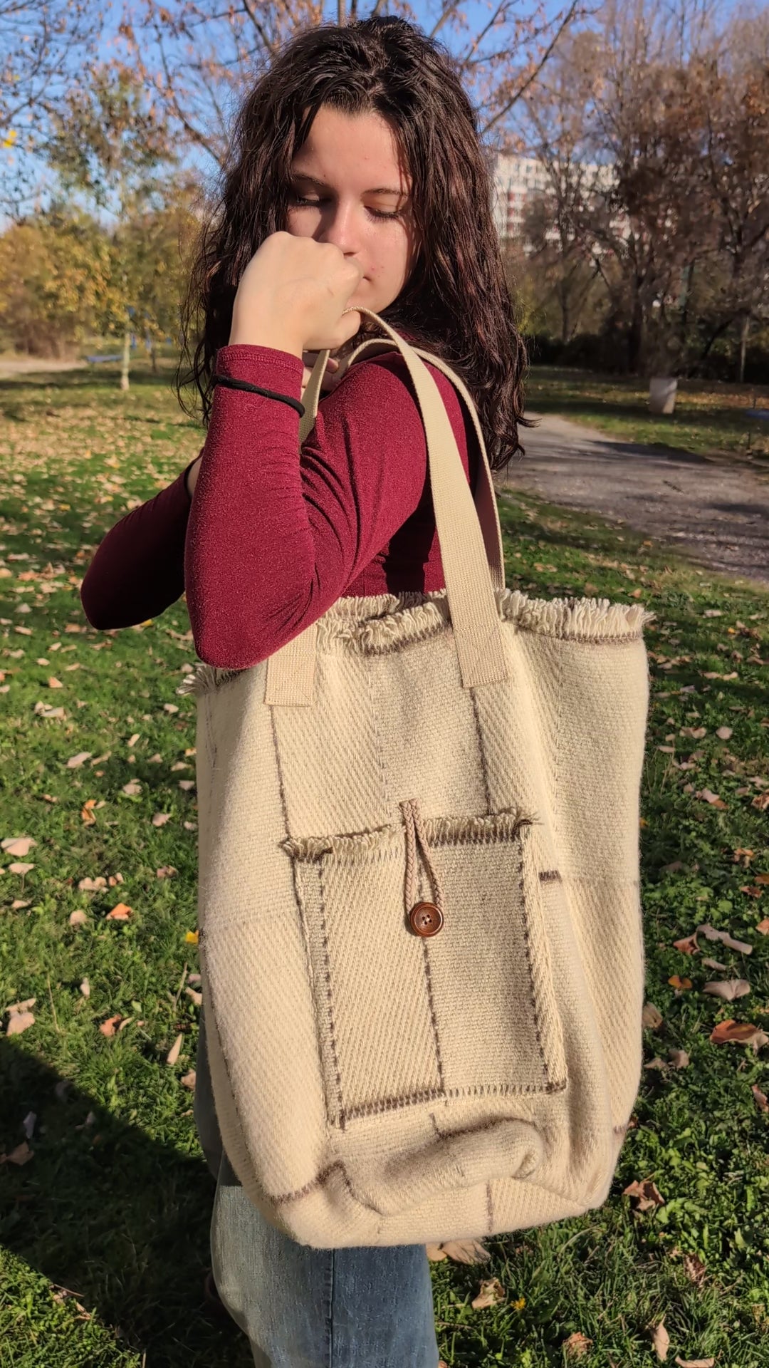 A video of a young girl wearing a modern minimalistic shopper bag or wool tote bag made from upcycled traditional blanket.