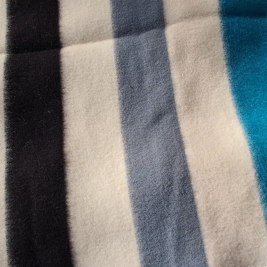 video of handspun virgin wool blanket with stripes in blue gray and green tones.