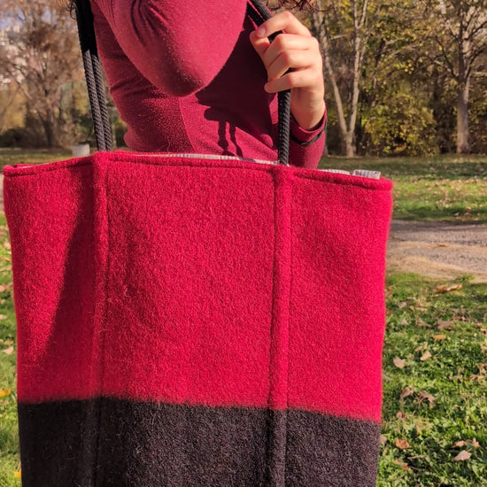 A modern statement slow fashion unisex  bag for all ages in deep red with a solid black stripe. 