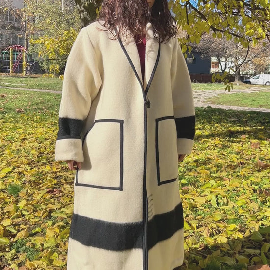 A woman wearing a luxury statement wool coat upcycled from pure wool  blanket. Belted wool robe coat - video