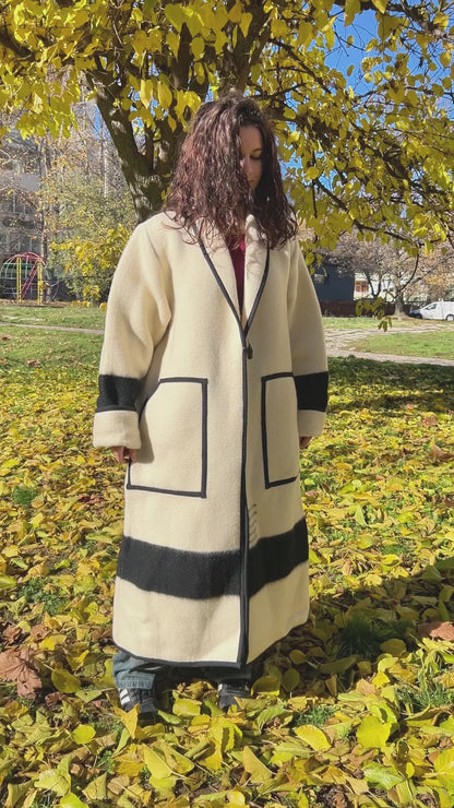 A woman wearing a luxury statement wool coat upcycled from pure wool  blanket. Belted wool robe coat - video