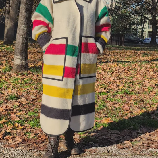 video of woman wearing a handmade tailored oversized duster coat, upcycled from artesan made pure wool blanket with multicolor stripes.