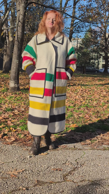video of woman wearing a handmade tailored oversized duster coat, upcycled from artesan made pure wool blanket with multicolor stripes.