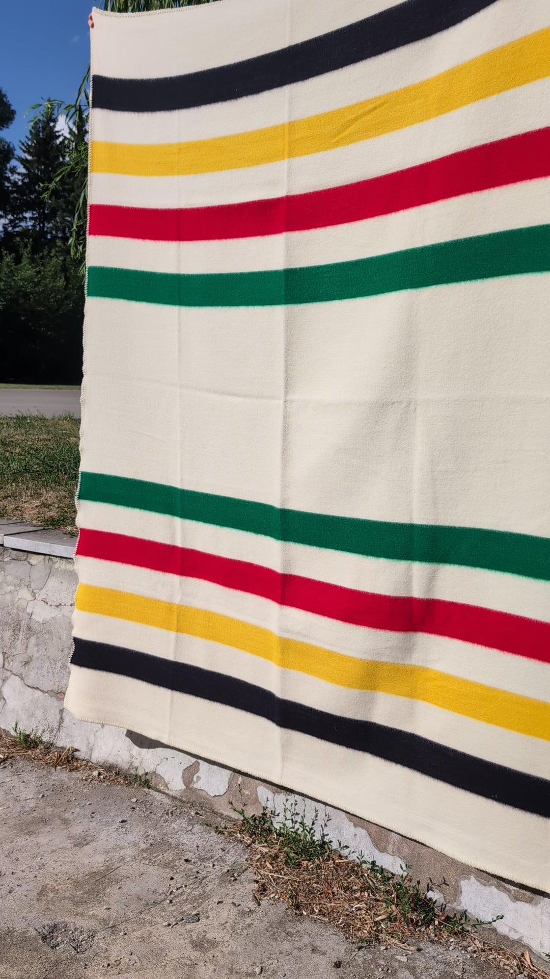 a video showing a multi-striped cabin blanket made of 100 percent eco wool with natural processing and coloring. 