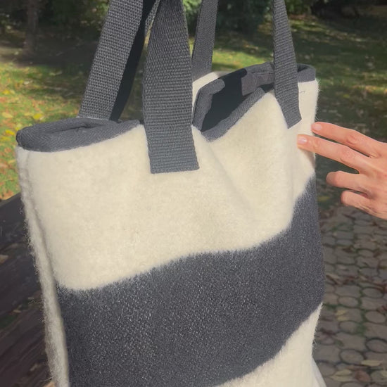 Video showing an off-white tote bag with black stripe at the front side.