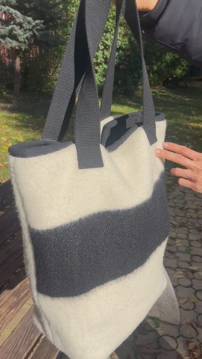 Video showing an off-white tote bag with black stripe at the front side.