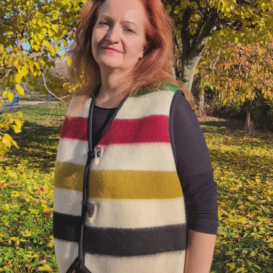 Video of a woman showcasing a wool stripe blanket vest, made-to-order and upcycled from a locally  handwoven wool blanket.