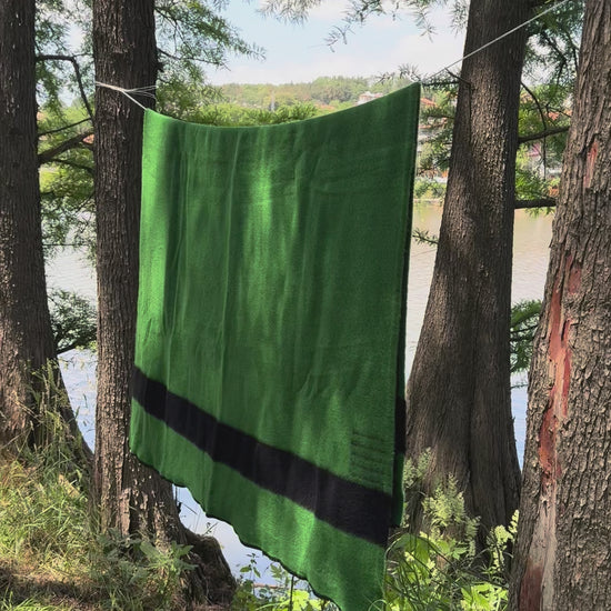 video of a classic traditional heirloom blanket. Green canadiana blanket with black stripes. 